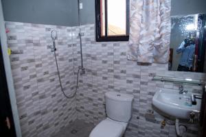 a bathroom with a shower and a toilet and a sink at BUJUMBURA Appart in Bujumbura