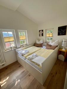 a white bedroom with a large bed with two windows at Ferienhaus Villa Frosch in Meiningen