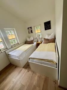two beds in a room with two windows at Ferienhaus Villa Frosch in Meiningen