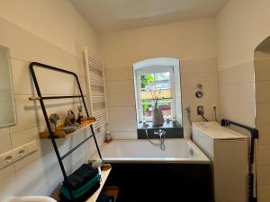 a bathroom with a bath tub and a window at Ferienhaus Villa Frosch in Meiningen