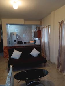 Una sala de estar con un sofá negro y una cocina. en Luthando's holiday apartment, en Amanzimtoti 21 fotos más
