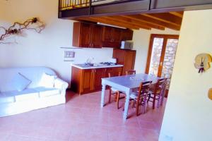 Una cocina y un comedor con mesa y sillas. en schönes Ferienhäuschen in ruhiger Lage für max. 4 Personen mit Pool, en Olzano