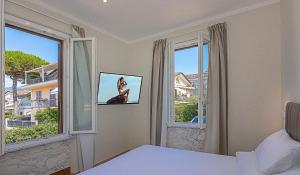 a bedroom with a bed and two large windows at Villa Gioietta in Marina di Massa
