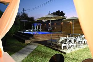 a pool with chairs and umbrellas in a yard at Pool Garden-Oaza in Skopje