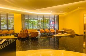 a lobby with yellow walls and chairs and windows at Axon Residence KLCC - KL HOME in Kuala Lumpur +168 photos