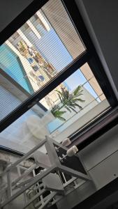 a window in a room with a view of a palm tree at Eva Del Mar 1, vedere la mare-parcare gratuita in Mamaia