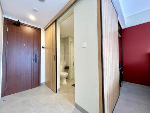 a bathroom with a toilet and a wooden door at Anaya Hotel Canggu in Canggu +46 photos
