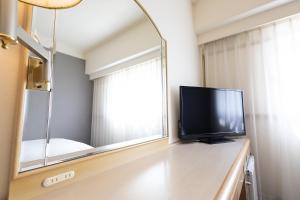 a flat screen tv sitting on a dresser in front of a mirror at Tottori Washington Hotel Plaza in Tottori