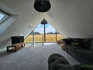 a living room with a couch and a tv at Field View in Elmswell