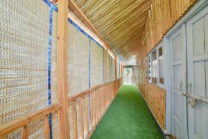 a hallway of a barn with green flooring and wooden walls at SAMALIA AGRO RESORT VRINDAVAN in Vrindāvan