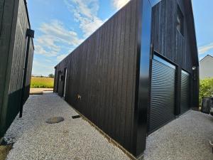 a black wall with doors on a building at Field View in Elmswell
