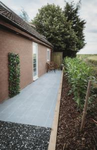 a patio with a bench on it next to a house at The Retreat- amazing scenic views of the Essex countryside! in Salcott