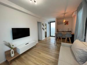 a living room with a flat screen tv on a wall at Casa en Sol - 5 min walk to Therme Balotesti in Baloteşti