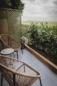 a patio with two chairs and a table at The Retreat- amazing scenic views of the Essex countryside! in Salcott
