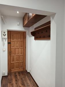 a hallway with a wooden door in a room at Apartament B&B in Stalowa Wola