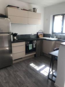 a kitchen with a stainless steel refrigerator and a table at Au près de tout in Neuvecelle