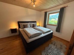 een slaapkamer met een groot bed en een raam bij Apartment Troger in Fieberbrunn
