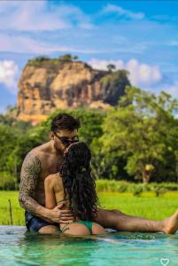 a man and a woman sitting in the water at Lankapura Heritage in Sigiriya