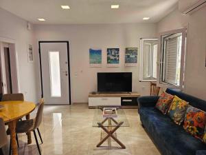 a living room with a blue couch and a television at Guarantee to make you say wow! in Athens