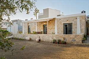 a house with a stone wall at Papadia Luxury Apartments in Pitsidia