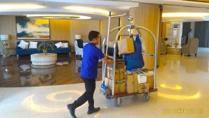 a man pushing a luggage cart in a lobby at Best staycation at Shell residences in MOA complex in Manila +42 photos
