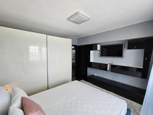 Un dormitorio con una cama y un televisor en una pared. en Blue Marina Sea View, en Mangalia