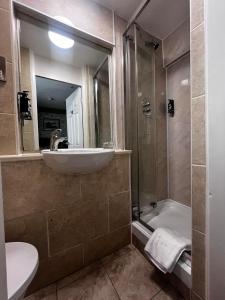 a bathroom with a sink and a shower with a mirror at Royal Victoria Hotel Snowdonia in Llanberis
