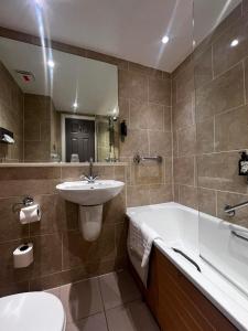 a bathroom with a sink and a tub and a toilet at Royal Victoria Hotel Snowdonia in Llanberis