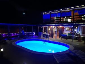 a swimming pool at night with tables and chairs at Casa Maza in Asque
