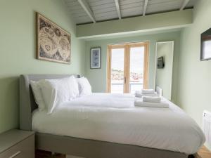 a bedroom with a large white bed with a window at Pass the Keys The Pontoon in Southend-on-Sea