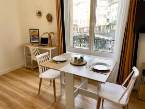 a dining room with a table and a window at Les Halles studio unique et cosy in Limoges