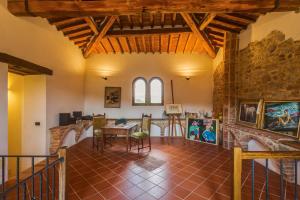 sala de estar con mesa y pared de piedra en Villa Il Cerretaccio, en Monti di Sotto