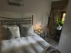 ein Bett mit weißen Laken und Kissen in einem Schlafzimmer in der Unterkunft Chalé do Maçarico in Fafe + 13 Fotos