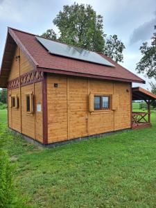 a large wooden building with a solar roof at Osada Drzonek in Ludomy
