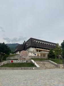 ein Gebäude mit einer Statue davor in der Unterkunft BlackMountain Hotel in Bajram Curr