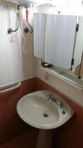 y baño con lavabo y espejo. en Hotel Centro, en Piriápolis
