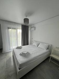 a bedroom with a white bed with towels on it at Cottages - Townhouses in Ureki