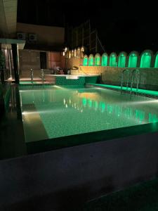 a swimming pool at night with green and blue lights at Hotel Royale Palace in Mount Ābu