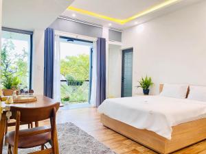 a bedroom with a bed and a desk and a window at Cloudy Homestay Hoi An in Hoi An