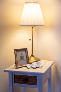 a table with a lamp and a picture on it at La Mansarda del Viandante in Castelbelforte
