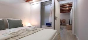 a bedroom with a white bed with towels on it at 1000Jo Apartment T2 in Gulpilhares
