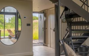 a spiral staircase in a house with a mirror at Wilder Retreats - A Frame Cabins in Haverfordwest