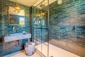 a bathroom with a glass shower and a sink at Wilder Retreats - A Frame Cabins in Haverfordwest