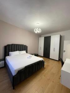 a bedroom with a large bed and white cabinets at Durres Vintage Apartment in Durrës