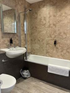 a bathroom with a sink and a tub and a toilet at Royal Victoria Hotel Snowdonia in Llanberis