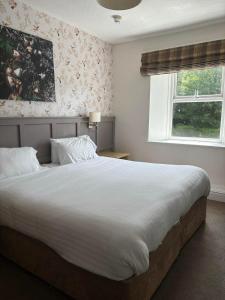a bedroom with a large bed and a window at Royal Victoria Hotel Snowdonia in Llanberis