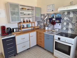 a kitchen with a white stove top oven next to a counter at Appartement Schaffhauser in Les Sables-d'Olonne