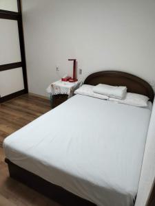 大阪Guesthouse Atelier Ten 民泊アトリエ天的房间里有一张白色的大床和一张桌子