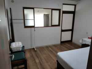 大阪Guesthouse Atelier Ten 民泊アトリエ天的客房设有一张床、一个窗户和木地板 更多43张照片