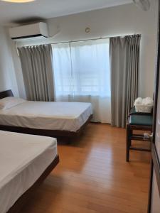 大阪Guesthouse Atelier Ten 民泊アトリエ天的有两张床和一扇窗户的酒店房间